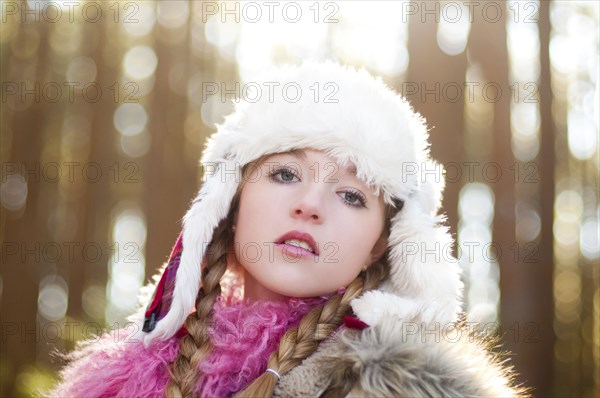 Caucasian teenage girl wearing fuzzy hat outdoors