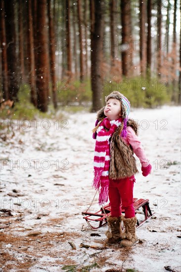 Caucasian girl catching snow on tongue