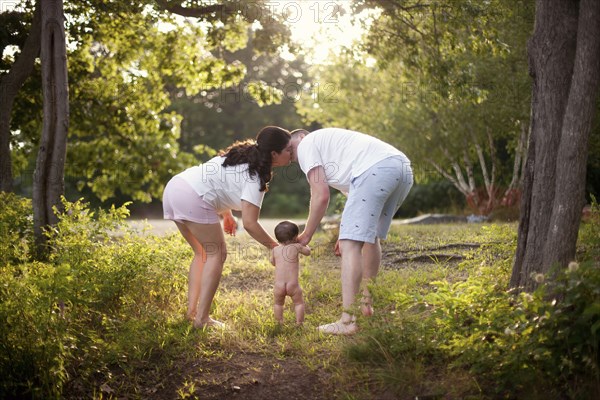 Parents and baby walking in garden