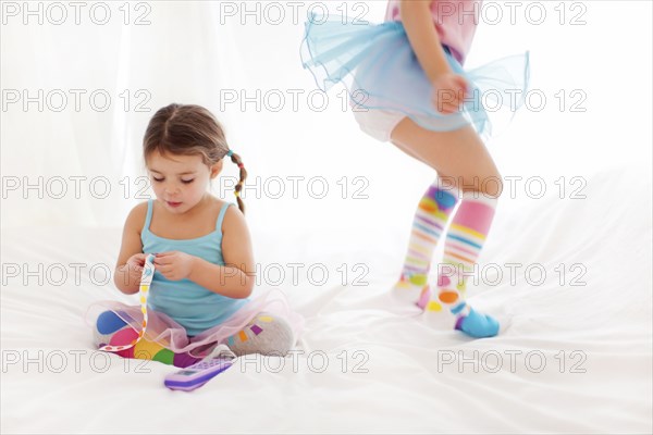 Caucasian girls playing on bed