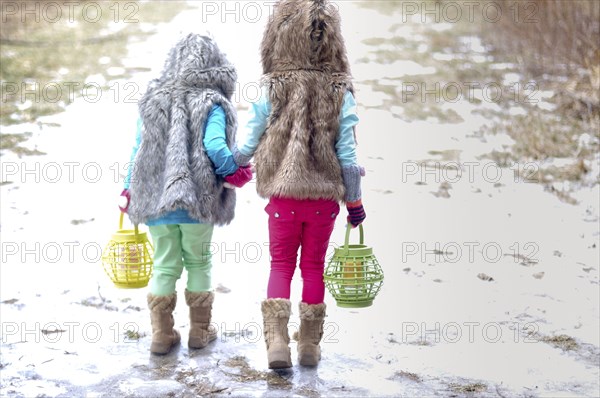 Caucasian girls holding hands in snow