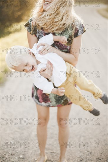 Mother lifting son outdoors