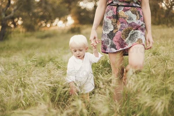 Mother and son walking in field