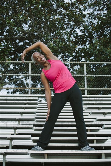 Woman stretching on bleachers