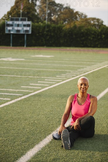 Woman stretching on football field