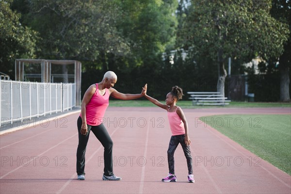 Grandmother and granddaughter high-fiving on track