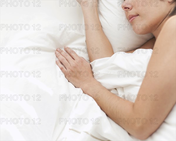 Hispanic woman sleeping in bed