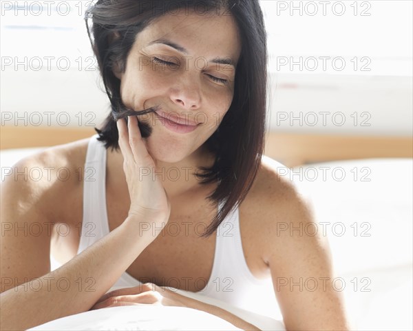 Smiling Hispanic woman sitting in bed