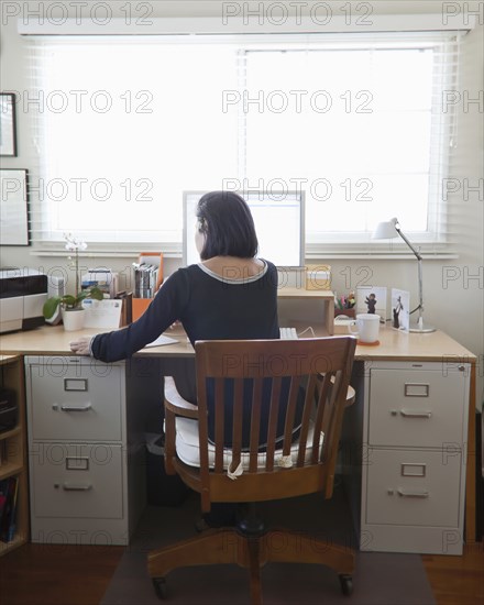 Hispanic woman working in home office