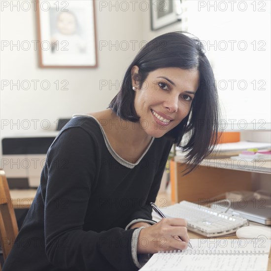 Hispanic woman working in home office