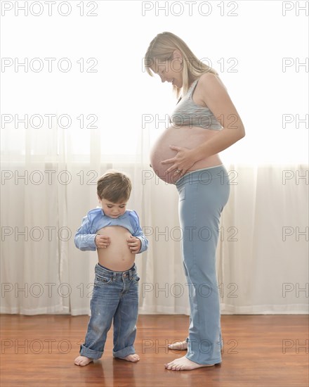 Caucasian boy imitating pregnant mother