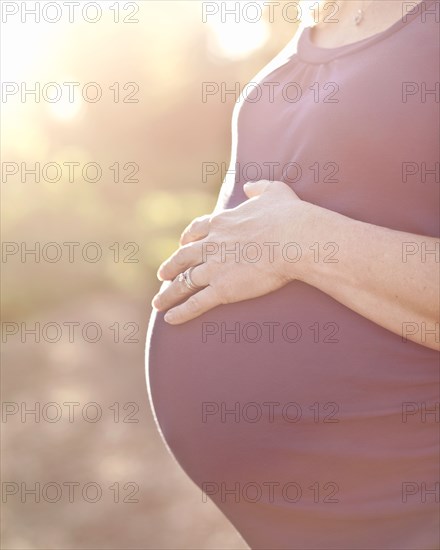 Pregnant Caucasian woman caressing stomach