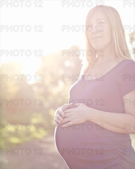 Pregnant Caucasian woman caressing stomach