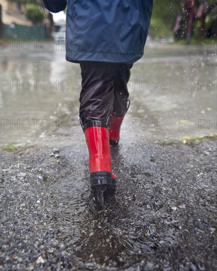 Caucasian boy walking in the rain