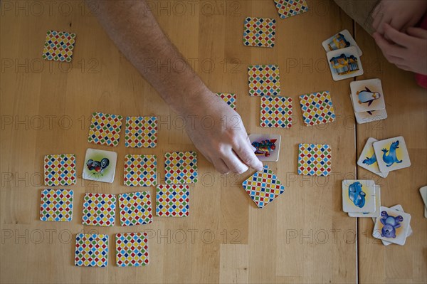 People playing tile game on wooden table