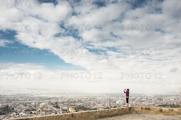 Caucasian woman photographing scenic view of cityscape
