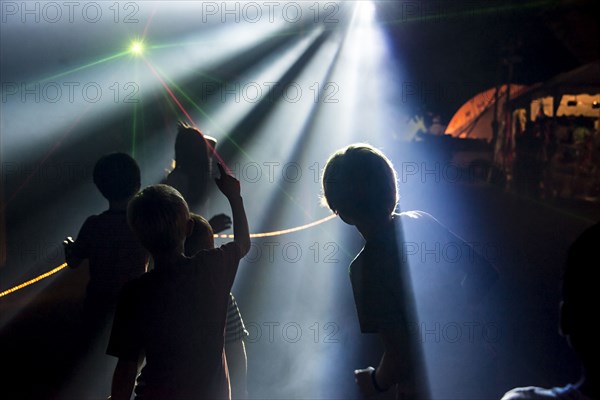 Silhouette of children under spotlights at night