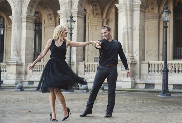 Caucasian couple dancing in courtyard