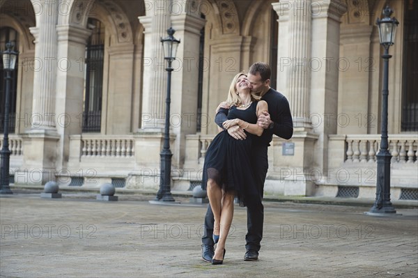 Caucasian couple dancing in courtyard