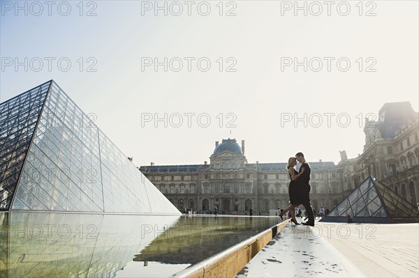 Caucasian couple kissing near ornate building