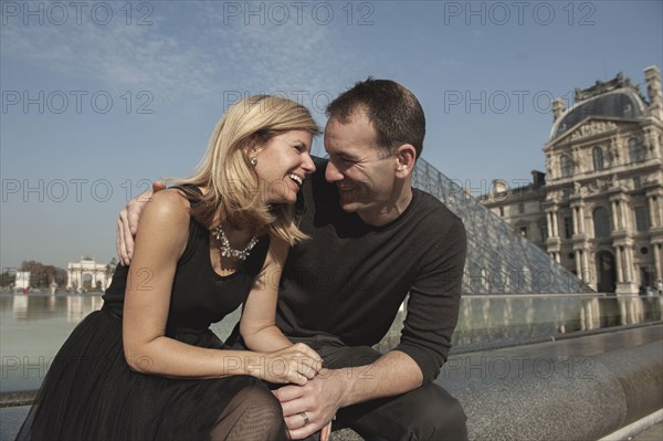 Caucasian couple laughing near fountain