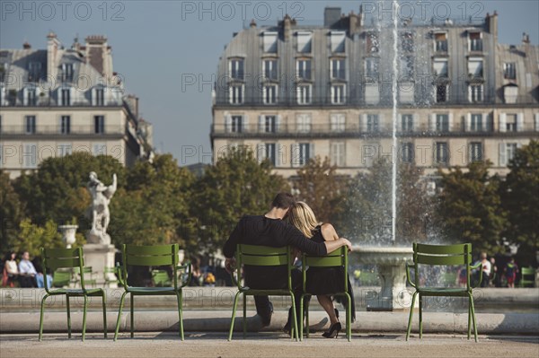 Caucasian couple admiring fountain in urban park