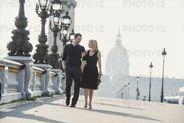 Caucasian couple walking on urban bridge