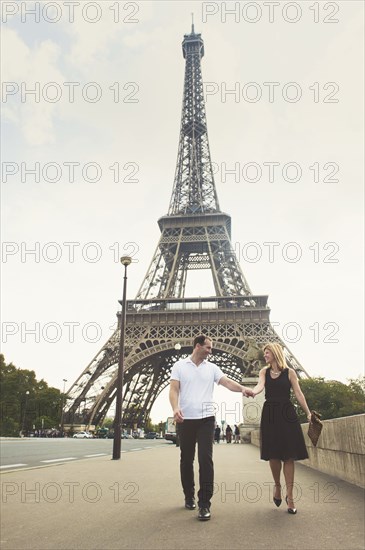 Caucasian couple walking near Eiffel Tower