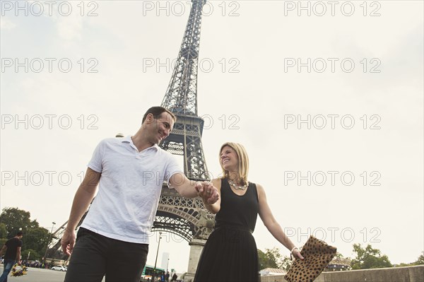 Caucasian couple walking near Eiffel Tower