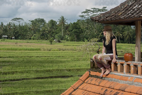 Caucasian woman overlooking rural fields from balcony