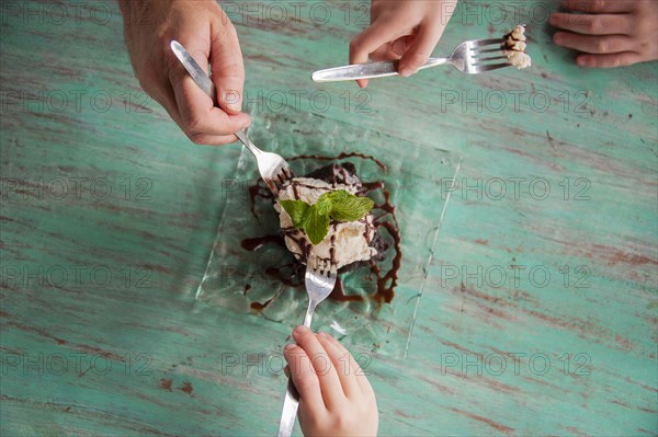 High angle view of hands reaching for food on plate