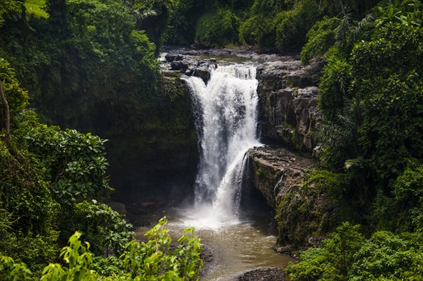 Waterfall flowing over rocky river in jungle