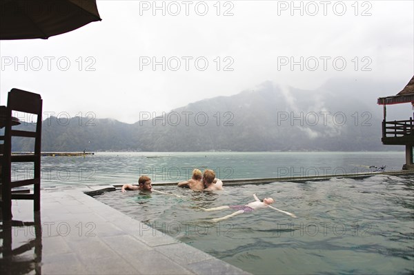 Caucasian children admiring scenic view from swimming pool