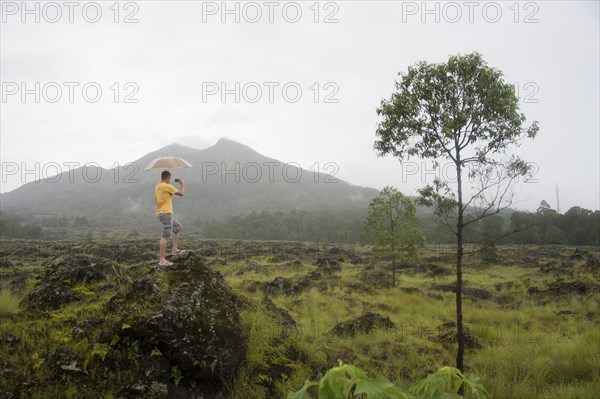 Caucasian tourist photographing scenic view of jungle