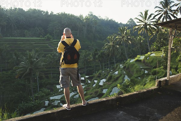 Caucasian tourist photographing rural rice terrace