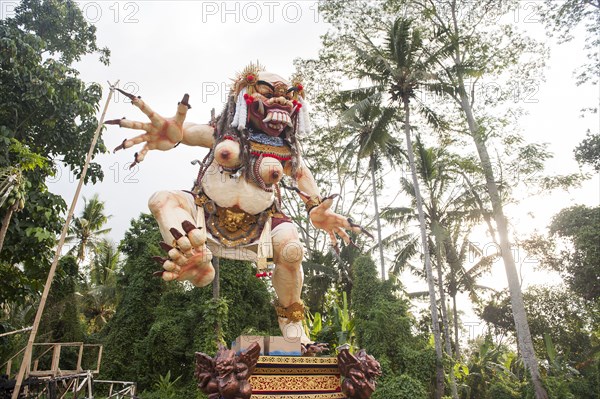 Statue of dancing deity in lush forest