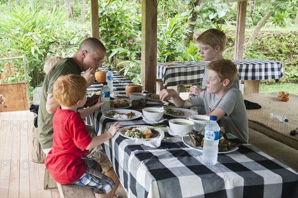 Caucasian family eating at picnic table outdoors