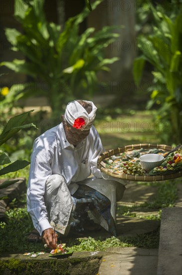 Asian artist creating sculptures on stone walkway