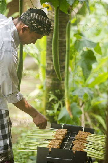 Asian chef cooking on grill outdoors