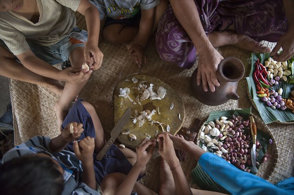 Asian family eating on woven mat