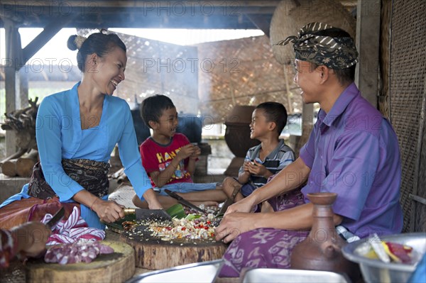 Asian family cooking together in outdoor kitchen