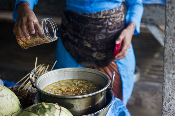 Asian chef cooking in outdoor kitchen