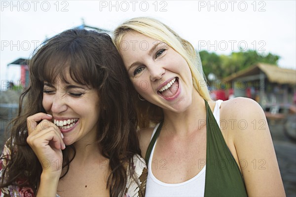 Caucasian women laughing on beach