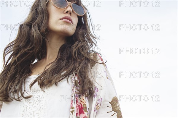 Low angle view of Caucasian woman wearing sunglasses outdoors