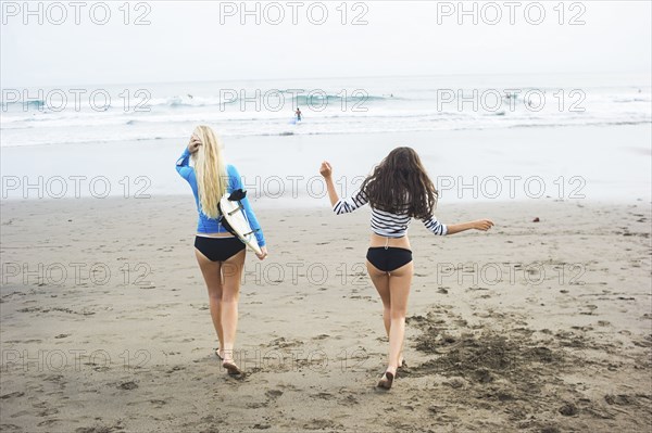 Caucasian women walking on beach