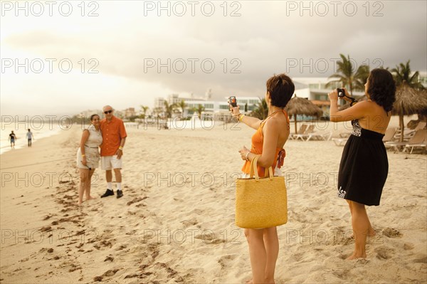 Family on beach vacation taking photographs