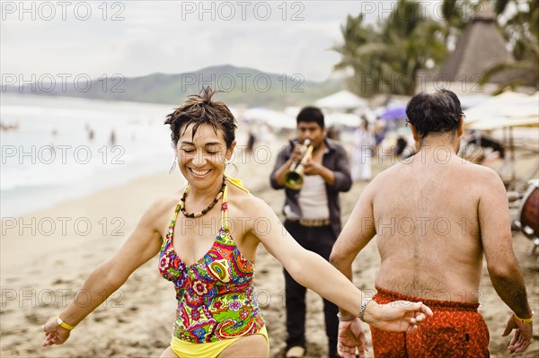 Hispanic people enjoying music on beach