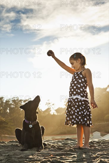 Mixed girl playing ball with dog