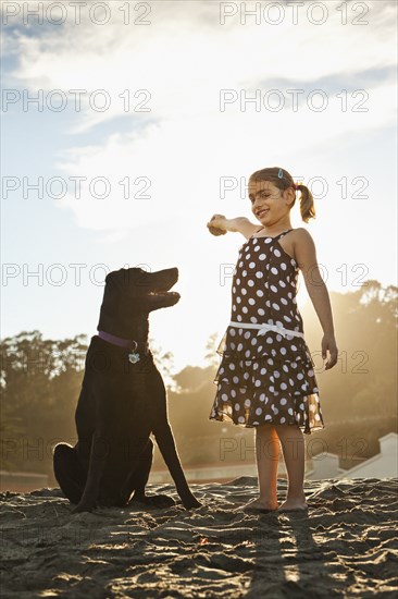 Mixed girl playing ball with dog