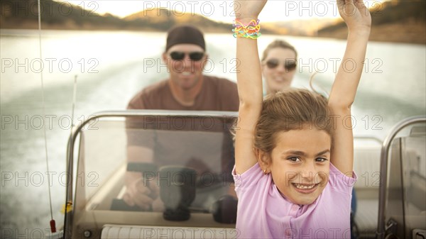 Girl and parents enjoying riding on boat